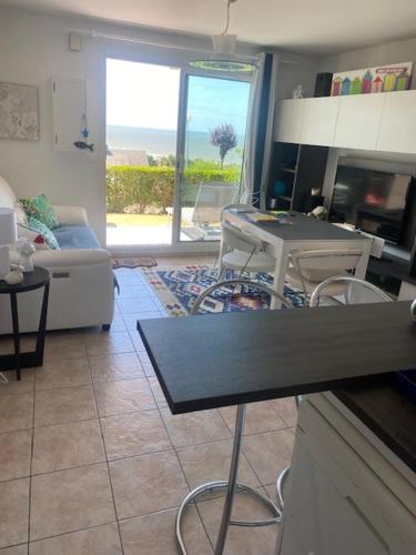 - un salon avec une table et une vue sur l'océan dans l'établissement Beautiful F3, sea view, panoramic, à Blonville-sur-Mer