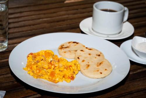 a plate with eggs and toast and a cup of coffee at Taironaka Eco Hotel in Don Diego
