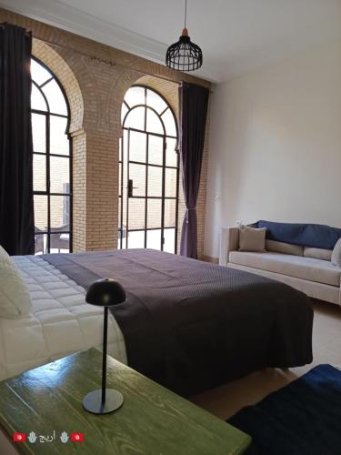 a bedroom with a large bed and a couch at Résidence Tozeur Almadina chambres Supérieures in Tozeur