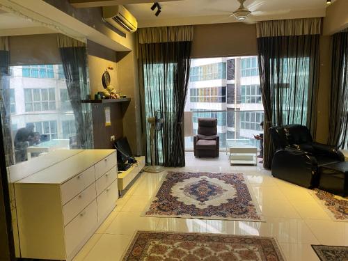 a living room with a large window and a couch and a chair at Celestial Heights Hostel featuring Infinity Skypool in Kuala Lumpur