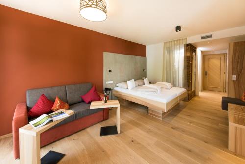 pokój hotelowy z łóżkiem i kanapą w obiekcie Hotel Der Löwe LEBE FREI w mieście Leogang