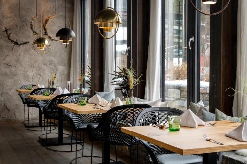 a restaurant with wooden tables and chairs and a window at Hotel Der Löwe LEBE FREI in Leogang