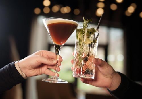 two people holding a drink in their hands at Hotel Der Löwe LEBE FREI in Leogang