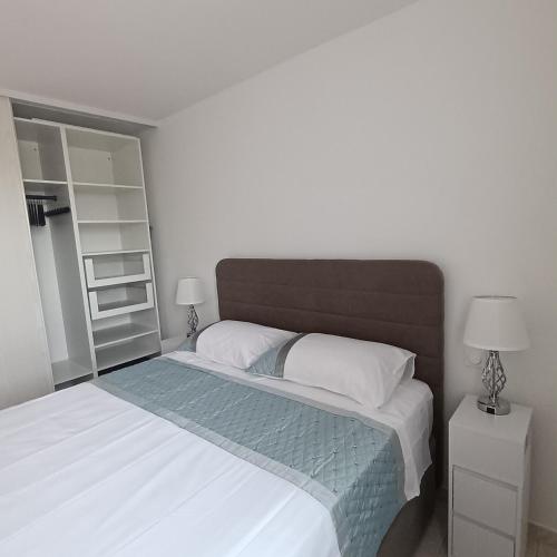 une chambre avec un grand lit avec des draps blancs dans l'établissement Bel appartement résidence lac Aurélien, à Fréjus