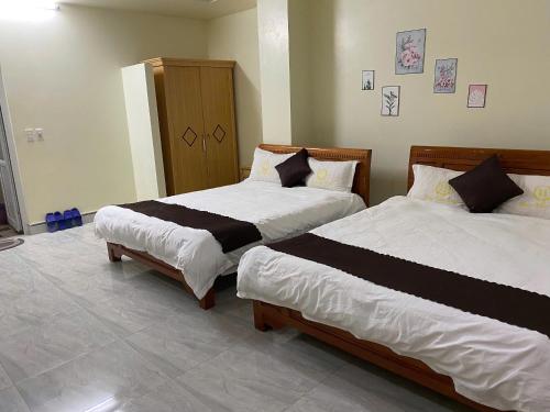 two beds sitting in a room with at Peaceful Mountain Hotel in Ha Giang