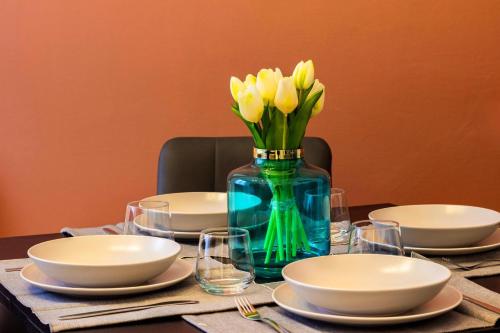 a table with a blue vase with yellow flowers in it at COMO The Walls House a pochi passi dal Centro Wi-Fi AC in Como