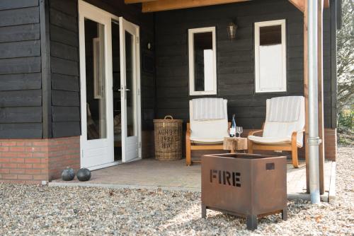 a house with two chairs and a box on a porch at B&B Logeren bij van Heeren in Made