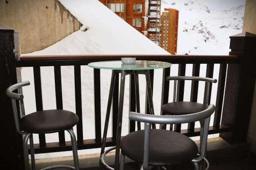 a table and two stools on a balcony with a table at HOM I Studio en Valle Nevado Valle Condores 1 in Lo Barnechea