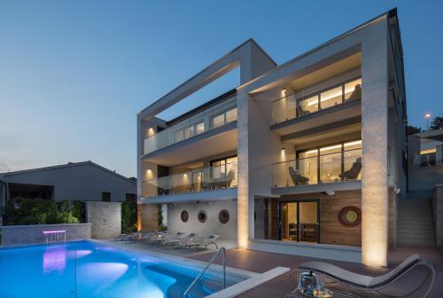 a large building with a swimming pool in front of it at Villa Vlastelini 2 in Labin