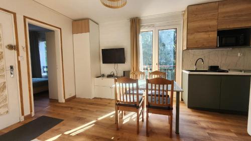 une cuisine avec une table et des chaises dans une pièce dans l'établissement Résidence-Sylvie-Luchon, à Luchon