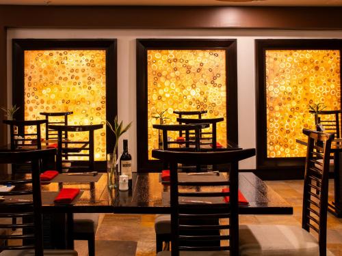a dining room with a table and chairs and windows at Swissotel Quito in Quito