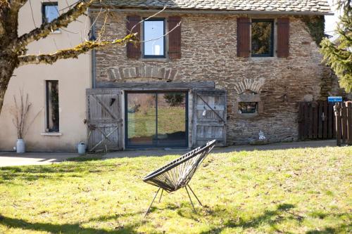 a chair in a yard in front of a house at Les Groseilliers in Moyrazès