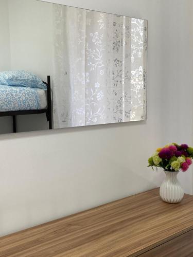 a vase of flowers on a table with a window at Largo Zeza Quindici in Boiano