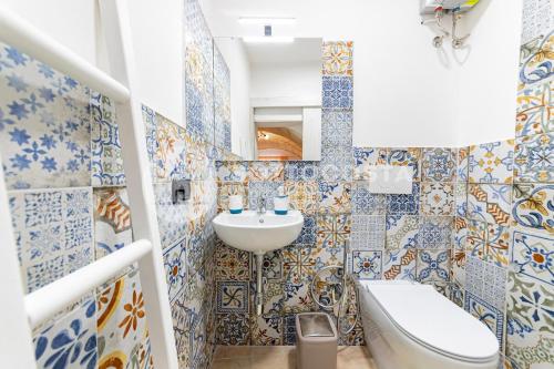 un bagno con piastrelle bianche e blu sul muro di Na Chicca - B&B a Melendugno