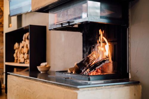 a stove with a fire inside of it at Hotel Der Löwe LEBE FREI in Leogang