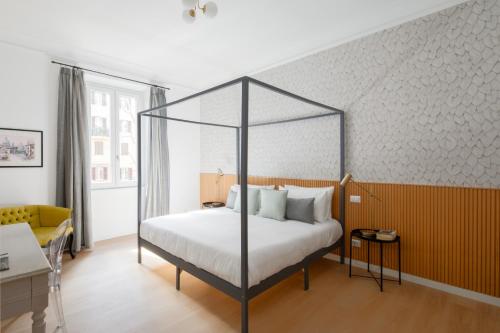 ein Schlafzimmer mit einem Himmelbett mit weißen Laken in der Unterkunft Aeterna Suites Roma in Rom