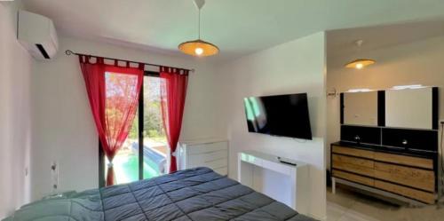 une chambre avec un lit et une télévision à écran plat dans l'établissement Spirit of Provence, à Carsan