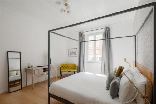 ein Schlafzimmer mit einem Bett und einem Schreibtisch mit einem gelben Stuhl in der Unterkunft Aeterna Suites Roma in Rom