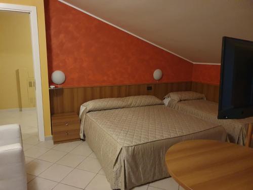 a bedroom with two beds and a flat screen tv at La Lanterna in Silvi Marina