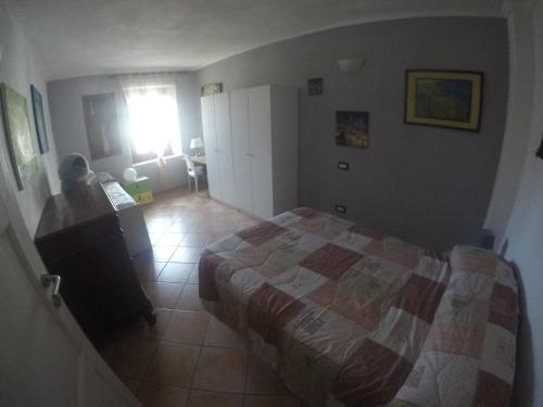 a small bedroom with a bed and a window at La casa di Pluto in Farigliano
