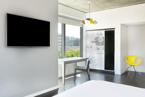 a room with a desk and a tv on a wall at Hotel Vance, Portland, a Tribute Portfolio Hotel in Portland