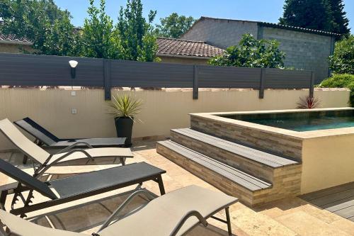 un patio avec des chaises et une piscine dans l'établissement The little house on the Isle air-conditioned house with swimming pool and, à LʼIsle-sur-la-Sorgue