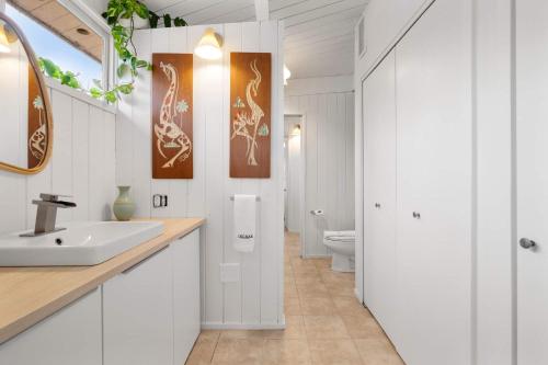 a white bathroom with a sink and a toilet at Tranquil Woodland Escape in Wellfleet in Wellfleet