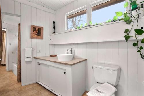 a white bathroom with a sink and a toilet at Tranquil Woodland Escape in Wellfleet in Wellfleet