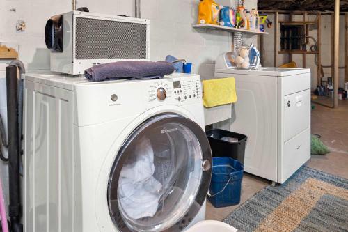 a washing machine with a microwave on top of it at Tranquil Woodland Escape in Wellfleet in Wellfleet