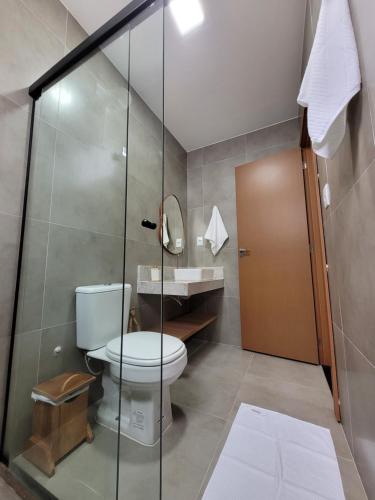 a bathroom with a toilet and a glass shower at Bahia Soul - Casa Bambu - Barra Grande - Península de Maraú in Barra Grande