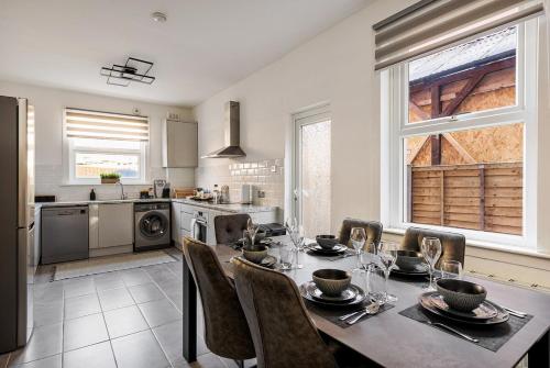 a kitchen and dining room with a table and chairs at Modern 4 Bedroom House In Woodgreen in London