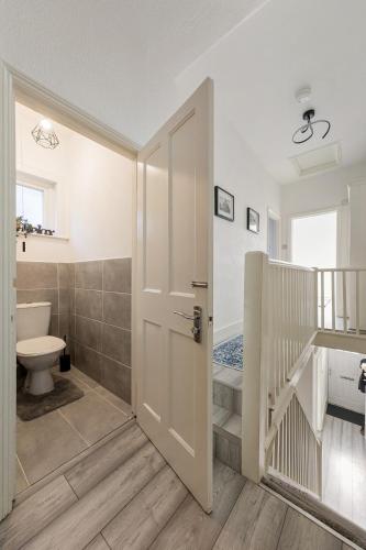 a bathroom with a toilet and a staircase at Modern 4 Bedroom House In Woodgreen in London