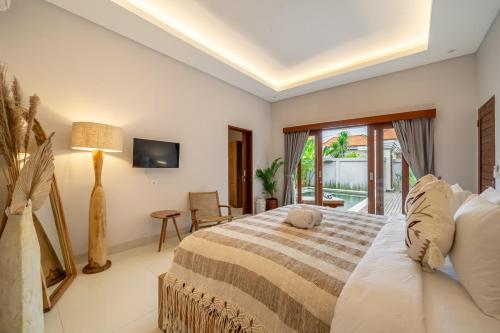 a bedroom with a large bed and a balcony at Private Pool, Perfect Location -Your Exclusive 3-Bedroom Villa in Canggu -Book Now! in Kerobokan