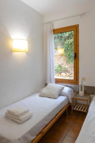 a bedroom with a bed and a window at Fee4Me Menorca Ideal Apartment 700m from the Sea in Arenal d'en Castell