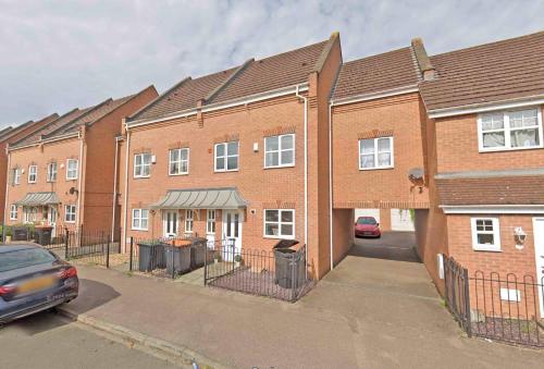 a brick building with a car parked in front of it at Miller House in Great location - Sleeps 14! Perfect for contractors in Bedford