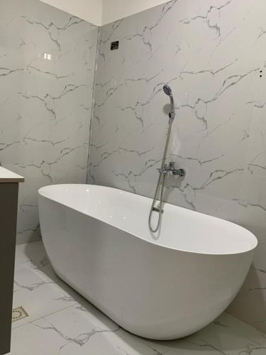 a white bath tub in a bathroom with marble walls at Villa Piagne Bastos in Yaoundé