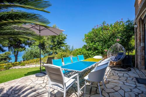 a patio with a blue table and chairs at Melitas Sea View Villa in Kassandria