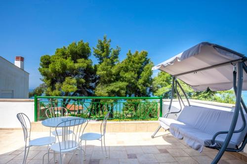 a patio with a table and chairs and an umbrella at Melitas Sea View Villa in Kassandria