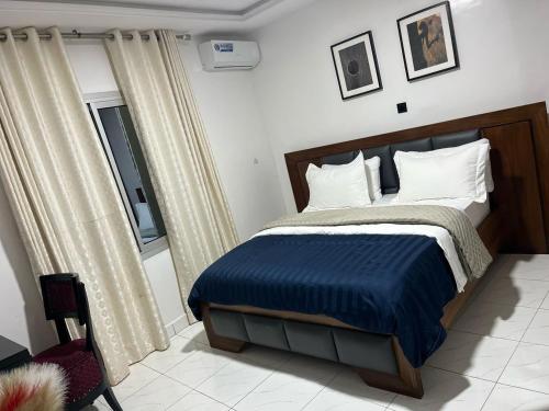 a bedroom with a bed with a blue comforter at Villa Piagne Bastos in Yaoundé