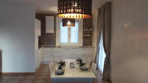 una cucina con tavolo e lampadario pendente di Residenza Leon a Castelnuovo del Garda