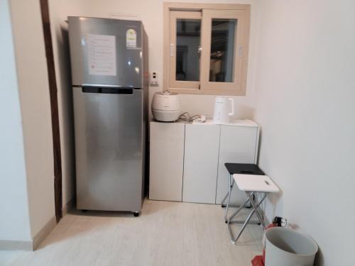 a kitchen with a stainless steel refrigerator in a room at Hongcheon Hanok Stay Scenery in Hongcheon