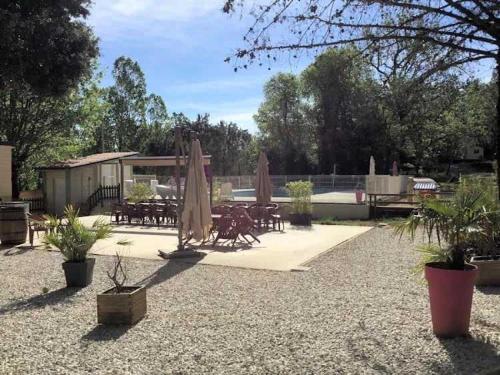 a patio with chairs and umbrellas and tables and chairs at Camping 3 étoiles - ccaiaah in Monoblet
