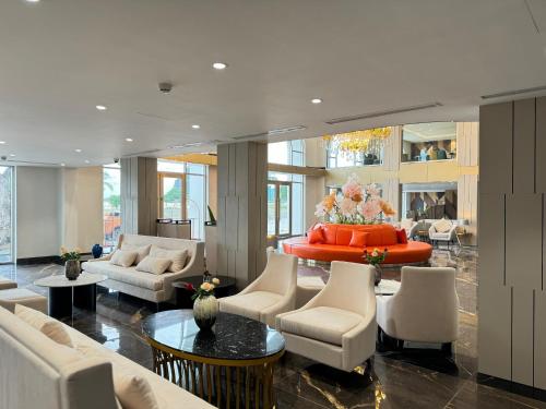 a living room with white furniture and a red table at Ao Tien Harbour Boutique Hotel in Hà Cái