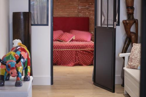 a living room with a doorway with a red couch at Le Loft in Montauban