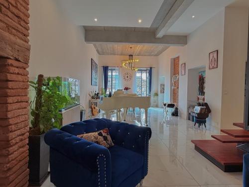 a living room with a blue couch and a dining room at Le Loft in Montauban