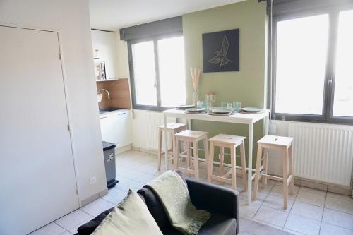 Il comprend un salon avec une cuisine équipée d'une table et de chaises. dans l'établissement Cosy Lafayette, à Lyon
