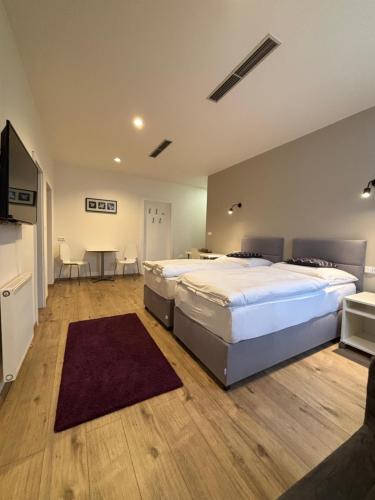 a bedroom with two beds and a table and chairs at Rozmaryn Rooms & Apartments in Rakovník