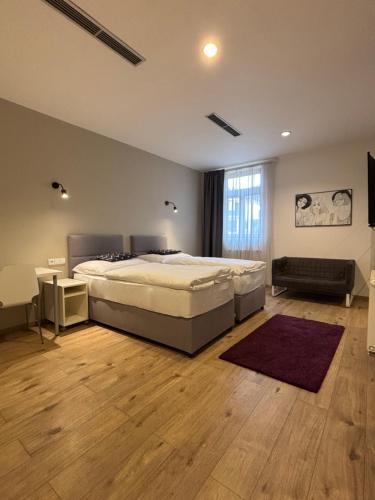 a bedroom with a large bed and a wooden floor at Rozmaryn Rooms & Apartments in Rakovník