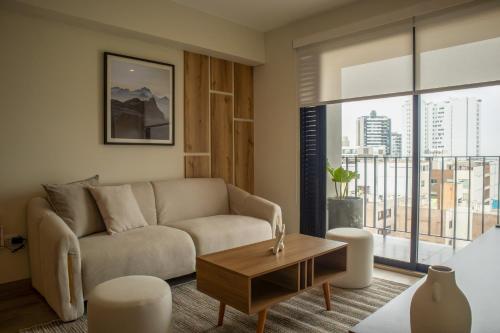 a living room with a couch and a table at Pod by Wynwood House in Lima
