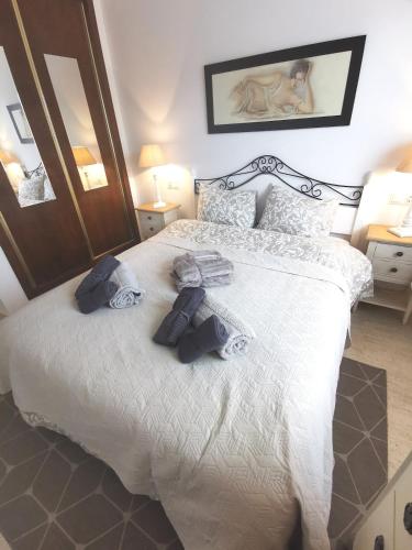 a bedroom with a large bed with towels on it at Gregorys Poolside Villa in Sucina